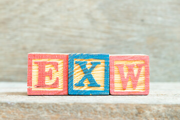 Color alphabet letter block in word EXW (abbreviation of Ex works)  on wood background