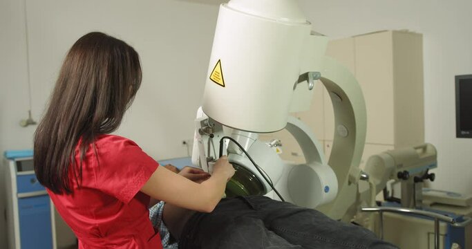 Ultrasound lithotripsy, non-surgical treatment to crush kidney, urethra, and bladder stones. Female doctor uses modern lithotriptor to break up kidney or gallbladder stones for male patient