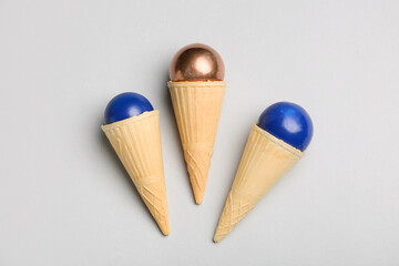 Wafer cones with light bulbs on grey background