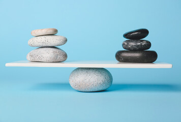 Spa stones on teeterboard against color background. Concept of balance