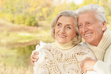 smiling senior couple hugging in autumn park