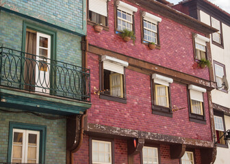 Red and green building facades with open windows