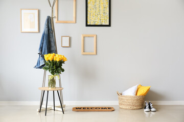 Vase with beautiful yellow roses on table in interior of hall