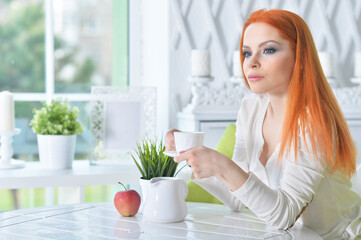 young beautiful woman drinking coffee at home