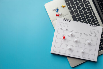 Calendar on solid ิblue background with copy space, pinned in a calender on datebusiness meeting schedule, travel planning or project milestone and reminder concept.