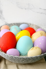 Bowl with beautiful Easter eggs on table, closeup