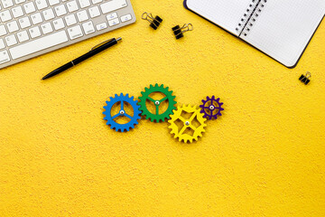 Business process and teamwork concept - working gears on office table, top view