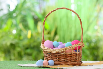 Fototapeta premium Basket with beautiful Easter eggs on grass outdoors