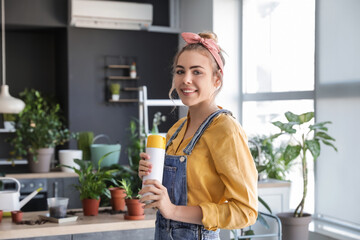 Young woman with air freshener at home