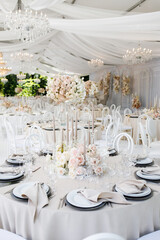 Festive wedding table setting with flowers, napkins, cutlery, glasses, bright summer table decor. Wedding decor