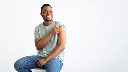 African Man Showing Vaccinated Arm With Medical Plaster, White Background - obrazy, fototapety, plakaty