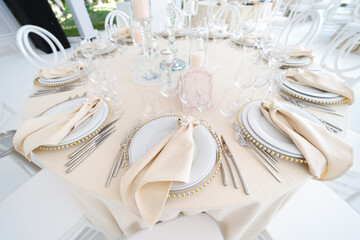 Festive wedding table setting with flowers, napkins, cutlery, glasses, bright summer table decor. Wedding decor