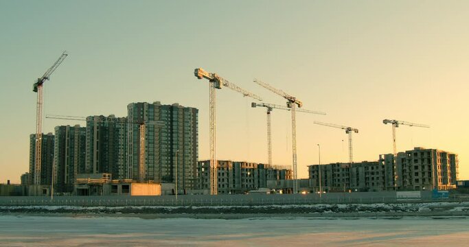 High cranes work at the construction site. Construction of multi-storey residential buildings (apartments).