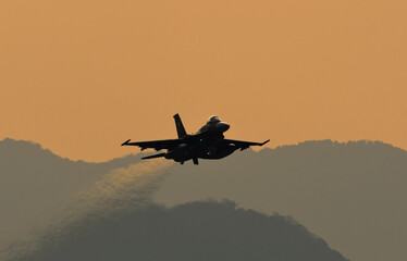 Fighter aircraft in evening sky.