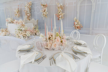 Festive wedding table setting with flowers, napkins, cutlery, glasses, bright summer table decor. Wedding decor