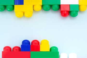 Plastic building blocks on a light blue background. Children's educational toys. Children's construction kit.
