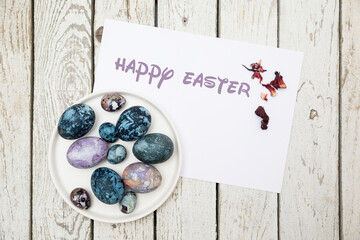 Easter eggs colored with hibiscus tea. Leaf with inscription Happy Easter.