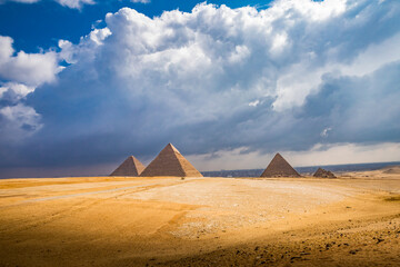 Wide landscape shot of Giza pryamids with dramatic clouds and light - obrazy, fototapety, plakaty