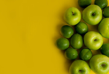 Persian lime (Limão-taiti) and Green Apples on yellow background