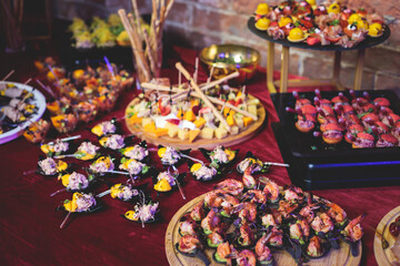 Catering table, beautifully decorated banquet with variety of with different food snacks and appetizers on corporate birthday party event or wedding celebration, seafood, canape, delicatessen setting