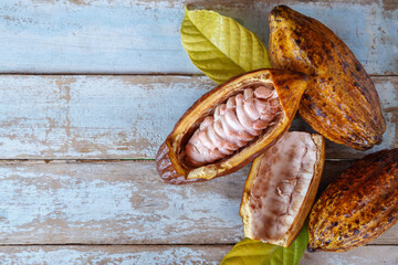 .Fresh cocoa pods and cocoa leaves on wooden background