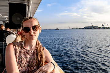 A young European woman rides a steamboat on the Dnieper river against the background of the Kherson...