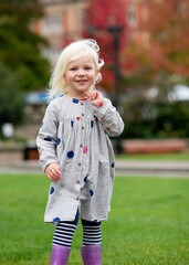 Fototapeta premium A little girl fooling and walking around in a city