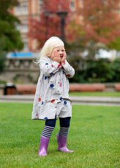 Fototapeta premium A little girl fooling and walking around in a city