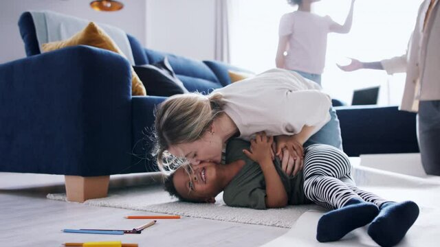 Multi ethnic family with two small children having fun at home.