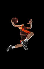 Plakat Young professional basketball player in action, motion isolated on black background, look from the bottom. Concept of sport, movement, energy and dynamic.