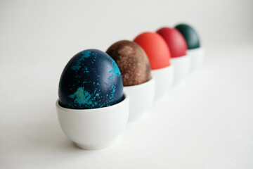 Easter eggs on porcelain stands on a white background