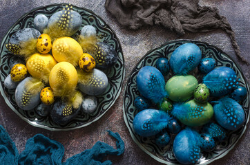 Painted eggs on the Easter table with feathers