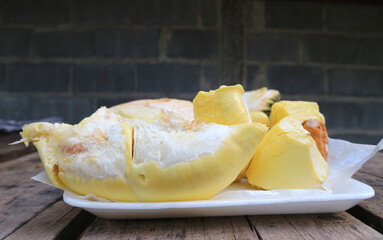 Pieces of fresh ripe durian on wooden table background.