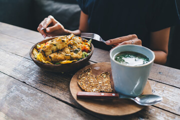 Female sitting in cafe and eating tasty food