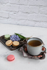 Obraz na płótnie Canvas Breakfast tea with macaroons on a wooden background with a hyacinth flower and a beautiful saucer. Vertical orientation