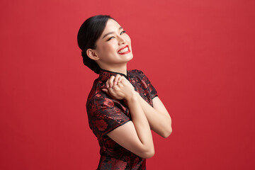 Asian chinese woman in traditional dress on red background. Chinese new year festival.