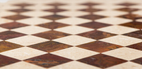 Naklejka premium Black and white checkered marble floor with sunlight