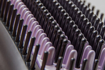 Obraz premium Background image of black and purple bristles of an electric heat brush for straightening hair