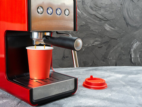 Red Coffee Machine Fills A Red Paper Cup. Coffee To Go.