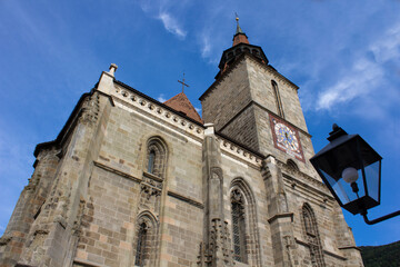 Fototapeta na wymiar Low angle view of Black Church clock tower from Brasov, Romania with clear blue sky