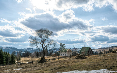 Fototapeta premium Beautiful rural landscape against the backdrop of the Carpathian Mountains in early spring