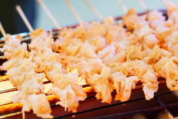 Close up of grilled Fresh jellyfish on wooden skewers, thai street food market