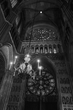 Beautiful interior of Reims Notre Dame Cathedral. Evening colorful illumination, stained glass windows, statues, nave. Reims, France. Black white historic photo.