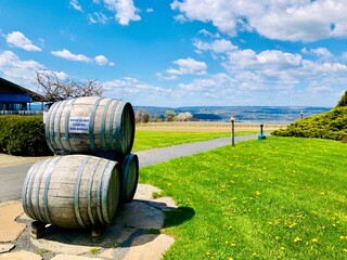 Three wooden wine barrels stacked outside of a winery, on lakeshore of Seneca Lake, in the Finger Lakes Wine Country, New York 