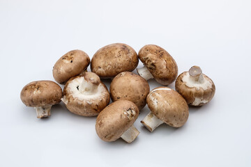 Schräg von oben: Braune Champignons / Pilze auf einem weißen Hintergrund