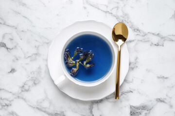 Organic blue Anchan in cup on white marble table, top view. Herbal tea