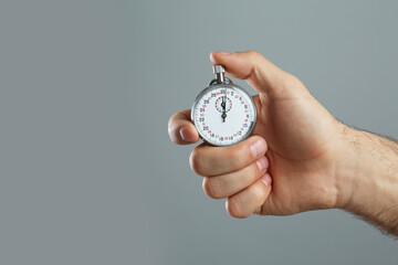 Man holding vintage timer on grey background, closeup. Space for text