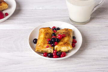 Rolled thin pancakes stuffed with cottage cheese and berries