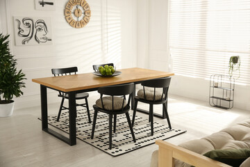 Stylish wooden dining table and chairs in room. Interior design