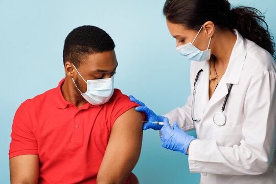 Black Man Getting Vaccinated Against Covid-19 Over Blue Studio Background